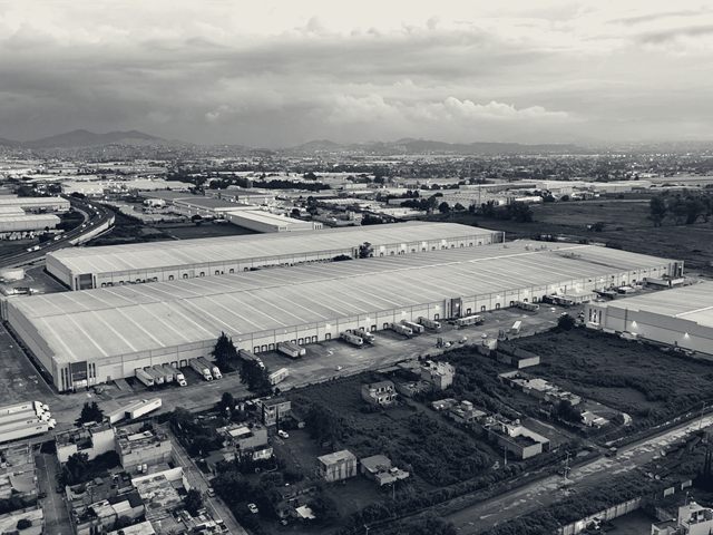 Aerial view of a very large distribution centre with a long dock frontage and truck hardstand